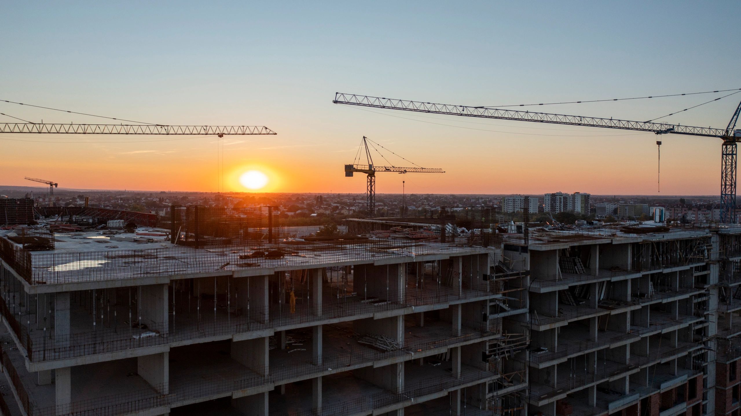 Large concrete building construction project at sunset